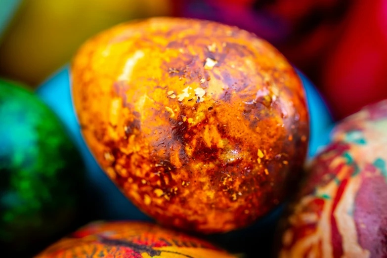 a pile of painted eggs sitting on top of a table, by Julia Pishtar, unsplash, bhut jolokia, bottom body close up, potato skin, with colourful intricate