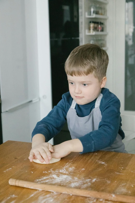 a little boy that is sitting at a table, in a kitchen, as well as scratches, instruction, up to the elbow
