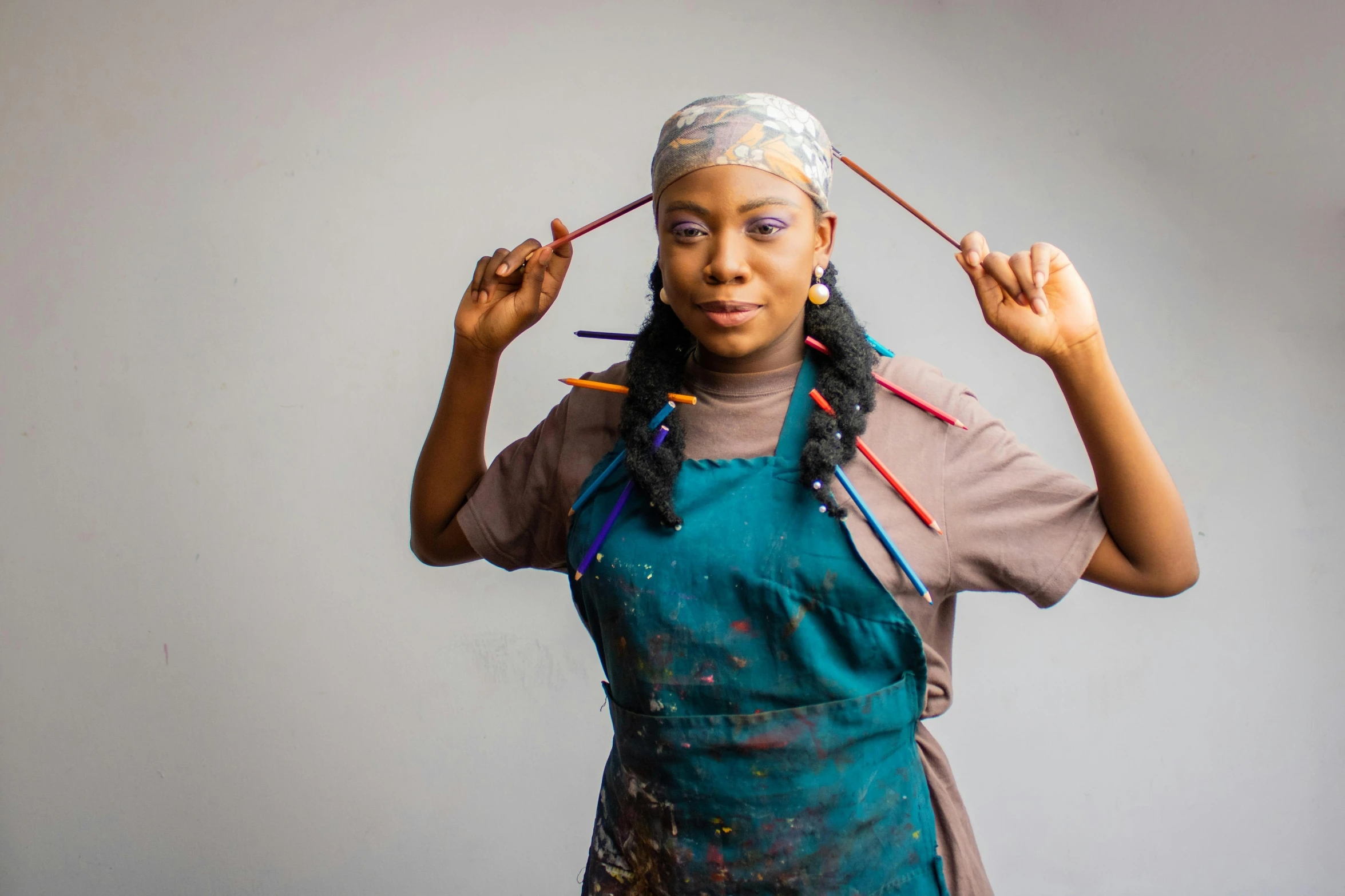 a woman holding a pair of scissors in one hand and a pair of scissors in the other, a portrait, inspired by Chinwe Chukwuogo-Roy, pexels contest winner, black arts movement, wearing an apron, unstirred paint, wearing a head scarf, holding pencil