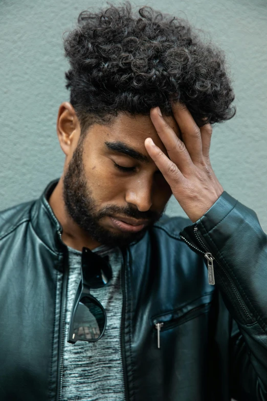 a man in a leather jacket holding his head, by Cosmo Alexander, trending on pexels, renaissance, ashteroth, with a sad expression, scruffy looking, instagram picture