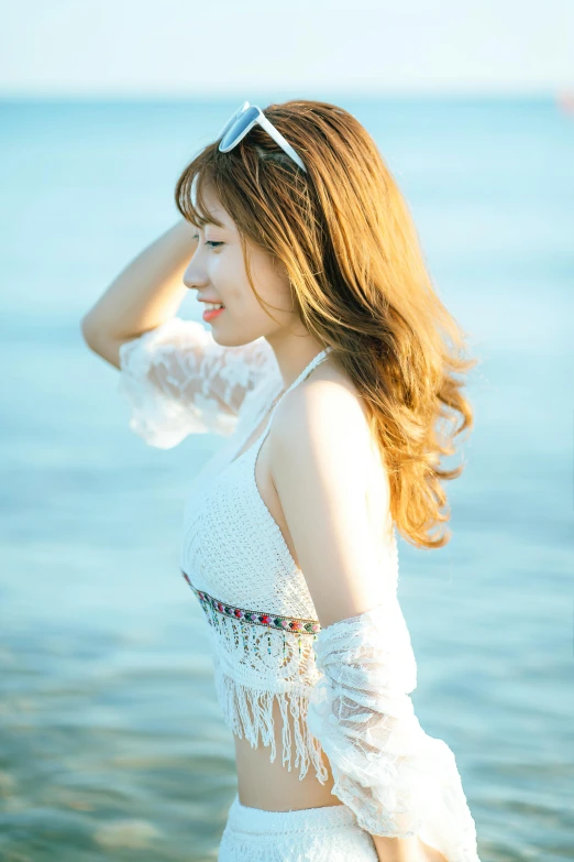 a woman standing on top of a beach next to the ocean, an album cover, inspired by Kim Jeong-hui, with brown hair, wearing a cute white dress, headshot profile picture, portrait mode photo