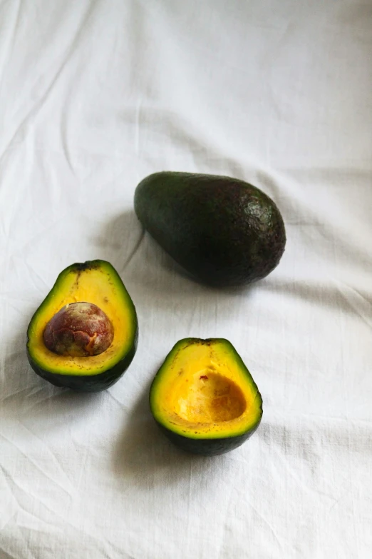 a couple of avocados sitting on top of a table, mid 2 0's female, gold, organics, detailed product image