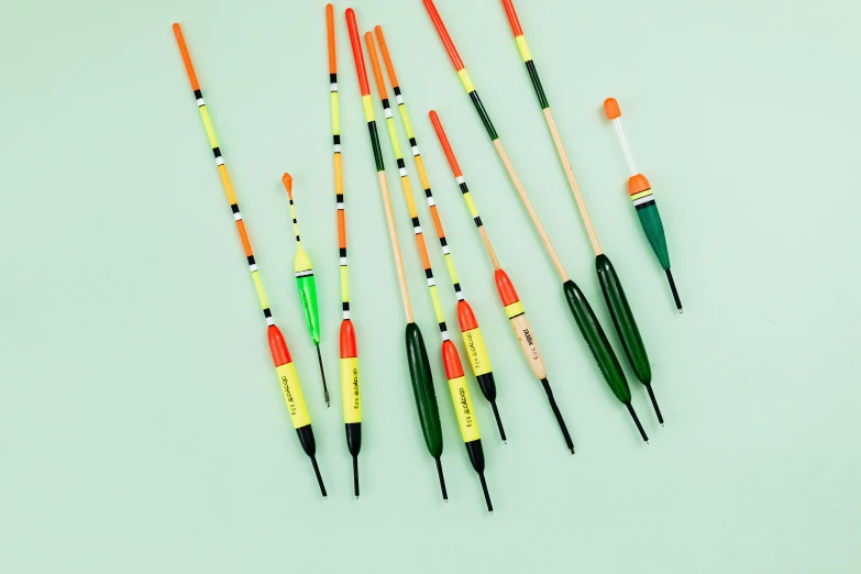 a group of crochet needles sitting next to each other, by Paul Bird, conceptual art, fish flocks, orange neon stripes, yellow and green scheme, launch tracking missiles