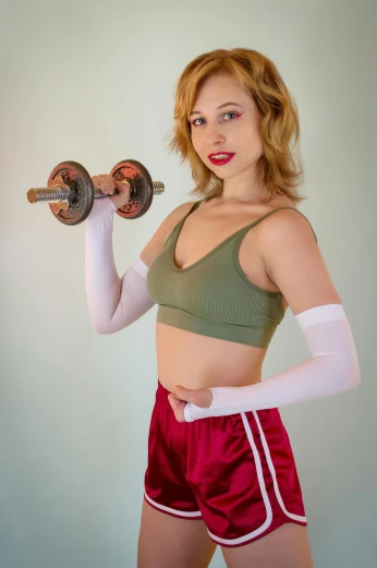 a woman in a green top and red shorts holding a pair of dumbbells, inspired by Gil Elvgren, featured on reddit, cosplay photo, y 2 k cutecore clowncore, portrait sophie mudd, wearing white leotard