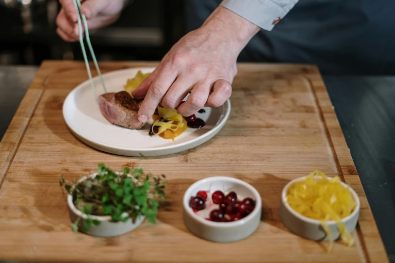 a person cutting food with chopsticks on a cutting board, inspired by Richmond Barthé, pexels contest winner, arbeitsrat für kunst, duck sits at a table, plating, swedish, thumbnail