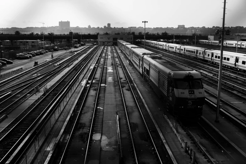a black and white photo of a train yard, a black and white photo, unsplash, in the middle of the city, 2000s photo, square lines, multiple stories