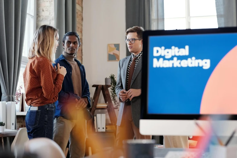 a group of people standing around a computer screen, digital marketing, brown, thumbnail, profile image