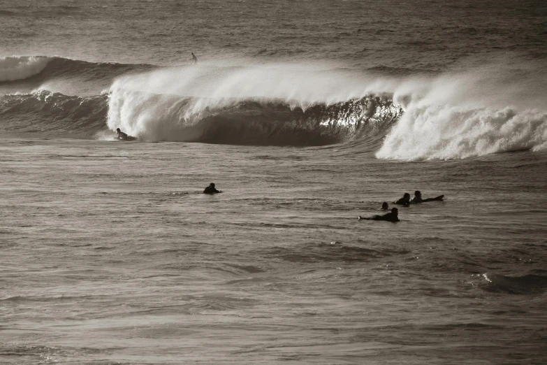 a group of people riding surfboards on top of waves, a black and white photo, by Andrew Bell, pexels contest winner, sepia tone, hollow, pipe jungle, cornwall