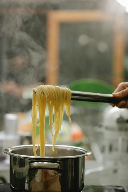 a person stirring pasta in a pot on a stove, pexels, process art, square, tournament, eats bambus, hanging