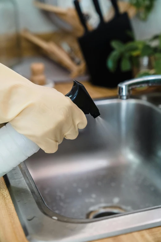 a person using a hand sanitizer to clean a kitchen sink, by Ben Zoeller, plasticien, elbow gloves, thumbnail, brown, cream