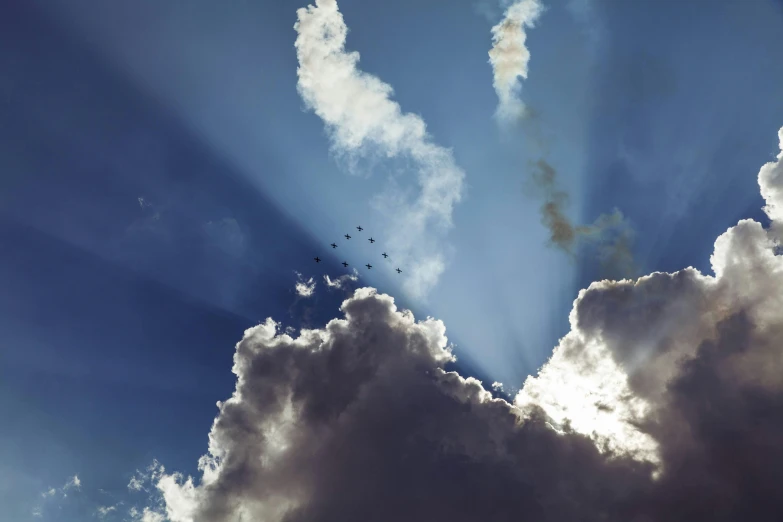 a group of birds flying through a cloudy sky, a photo, by Bertram Brooker, pexels contest winner, precisionism, sunbeams blue sky, fighter jets, ceremonial clouds, wide high angle view