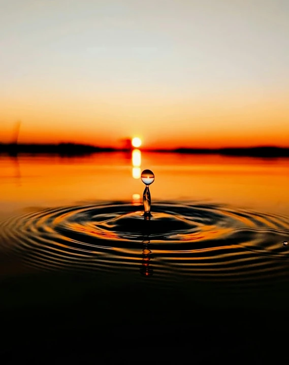 a drop of water in the middle of a body of water, with a sunset, lgbtq, rippling, facebook post