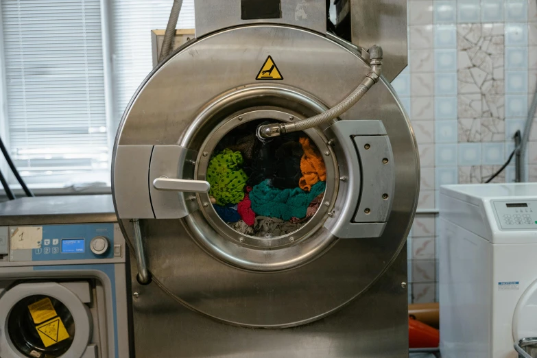 a washing machine with a bunch of clothes inside of it, by Petr Brandl, pexels contest winner, process art, inside a science facility, stainless steel, round format, various colors
