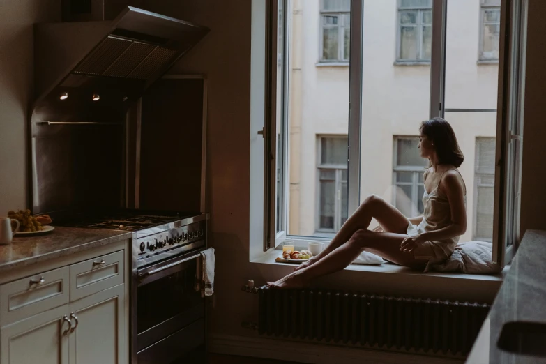 a woman sitting on a window sill in a kitchen, inspired by Elsa Bleda, unsplash contest winner, in the bedroom at a sleepover, photo of slim girl, viktoria gavrilenko, in the kitchen