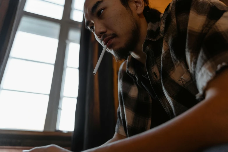 a man sitting in front of a laptop computer, pexels contest winner, holding a cigarette, asian descent, avatar image, profile image