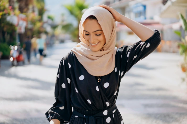 a woman wearing a black and white polka dot dress, inspired by Modest Urgell, trending on pexels, hurufiyya, wearing a head scarf, silky smooth, malaysian, date