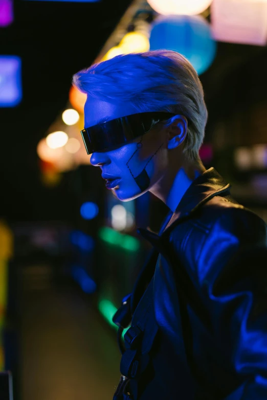 a man standing in front of a laptop computer, cyberpunk art, trending on pexels, police lights shine on her face, attractive androgynous humanoid, bladerunner street alley, digital sunglasses