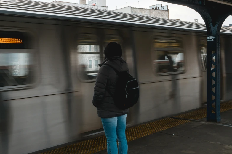 a woman waiting for a train at a train station, pexels contest winner, graffiti, wearing jeans and a black hoodie, watching new york, youtube thumbnail, faceless people