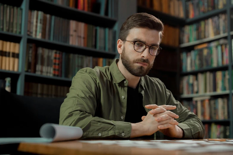 a man sitting at a table in front of a laptop computer, a digital rendering, pexels contest winner, academic art, library nerd glasses, handsome man, architect, caleb from critical role