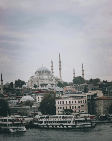 a group of boats floating on top of a river, a colorized photo, by Ismail Acar, pexels contest winner, hurufiyya, neoclassical tower with dome, grayish, paisley, trending on vsco
