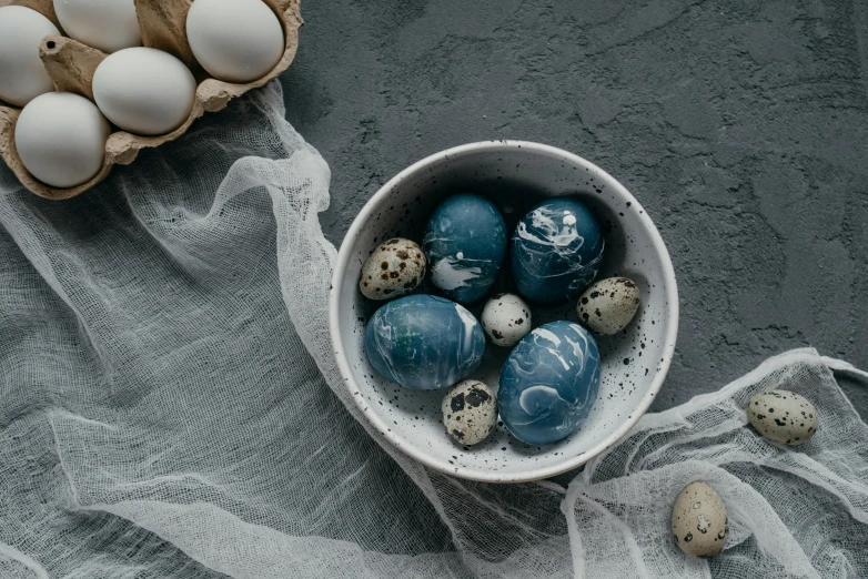 a bowl filled with eggs sitting on top of a table, inspired by Louis Le Nain, trending on unsplash, baroque, monochromatic blue, candy decorations, high quality product image”, grey