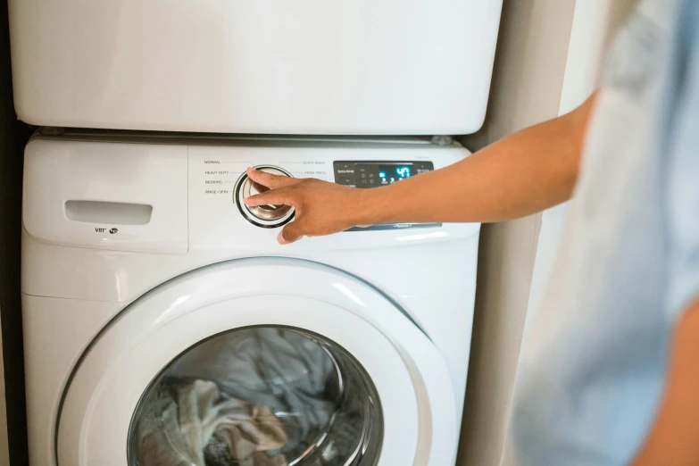 a person standing in front of a washing machine, point finger with ring on it, sustainable materials, glossy white, avatar image