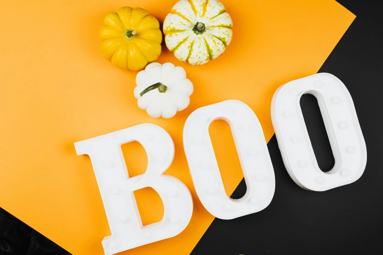 the word boo spelled in white letters next to pumpkins and gourds, a portrait, trending on pexels, background image, white and yellow scheme, spooky lighting, viewed from the side