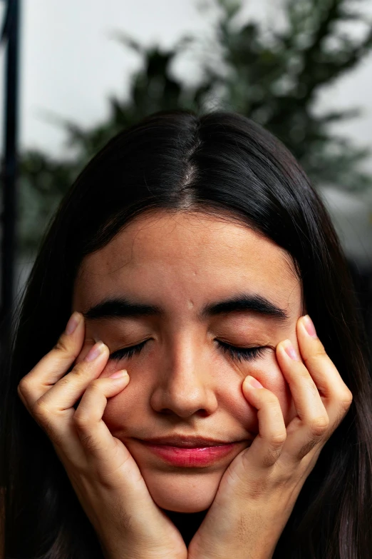 a close up of a person holding their hands to their face, happily tired, two eyes half closed, distorted pose, she's sad