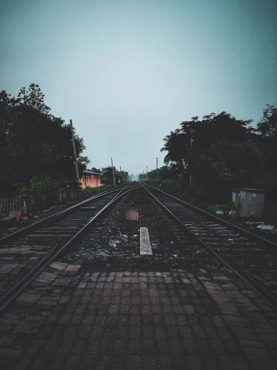 a couple of train tracks sitting next to each other, an album cover, unsplash contest winner, assamese aesthetic, spooky photo, early evening, unedited