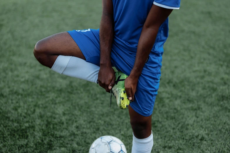 a man standing next to a soccer ball on a field, leg and thigh shot, ( ( dark skin ) ), 15081959 21121991 01012000 4k, stretch