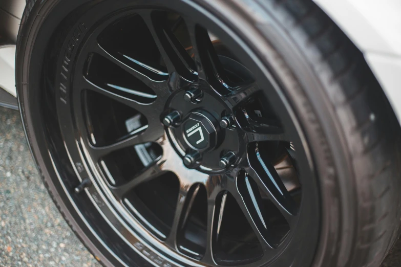 a close up of a tire on a car, ixions wheel, black resin, roadster, full dynamic colour