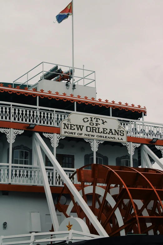 a large boat sitting on top of a river, poster art, by Carey Morris, trending on unsplash, art nouveau, new orleans, exterior view, 1999 photograph, sign