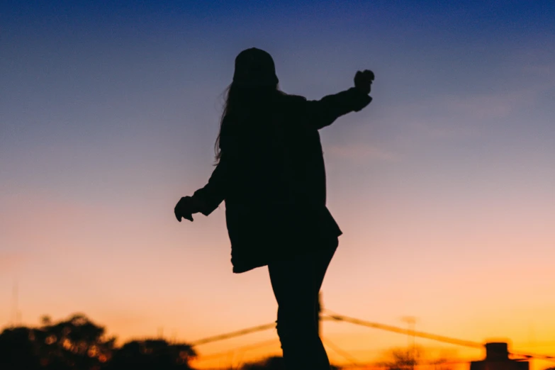 a silhouette of a person on a skateboard at sunset, pexels contest winner, happening, girl standing, shrugging arms, slightly blurred, pose 4 of 1 6