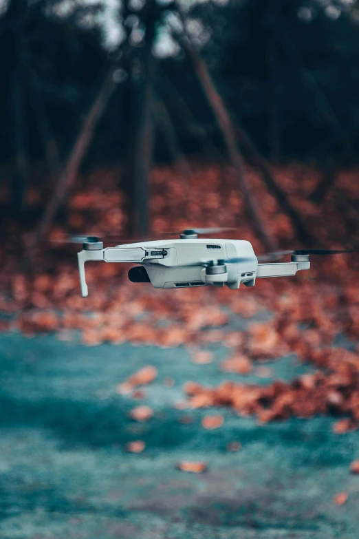 a white drone flying over a body of water, flying leaves on backround, 2019 trending photo, electronics, ground - level medium shot