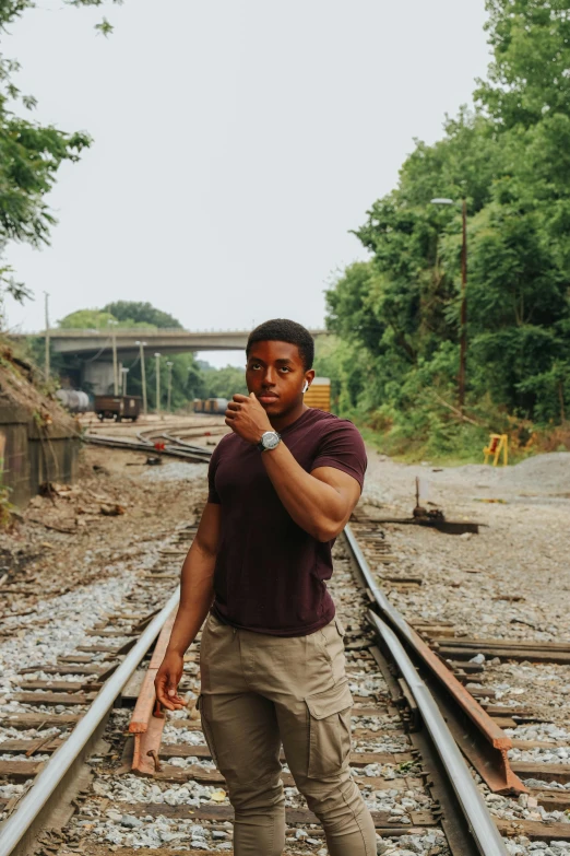 a man standing on a train track smoking a cigarette, pexels contest winner, renaissance, mkbhd as iron man, super buff and cool, teddy fresh, on location