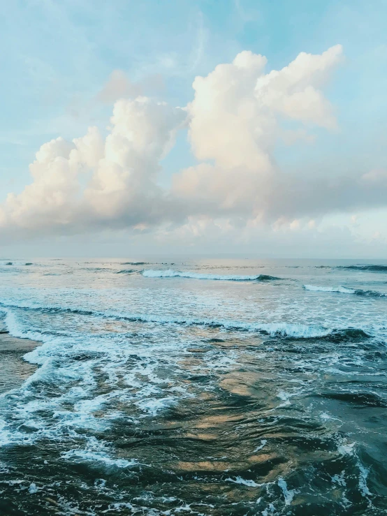 a man standing on top of a beach next to the ocean, pexels contest winner, pristine rippling oceanic waves, clouds on surface, bali, today\'s featured photograph 4k