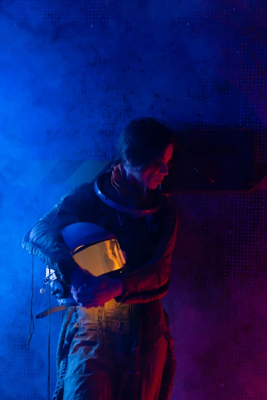a man holding a guitar on top of a stage, by Alison Watt, space suit with a modern helmet, dusty lighting, production photo, the expanse