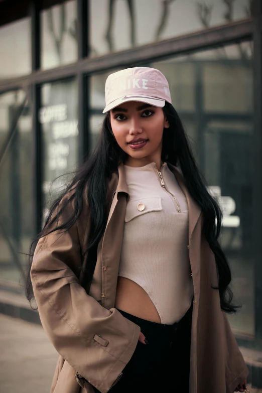 a woman standing on a sidewalk in front of a building, outlive streetwear collection, nicki minaj, wearing a baseball cap, demi rose