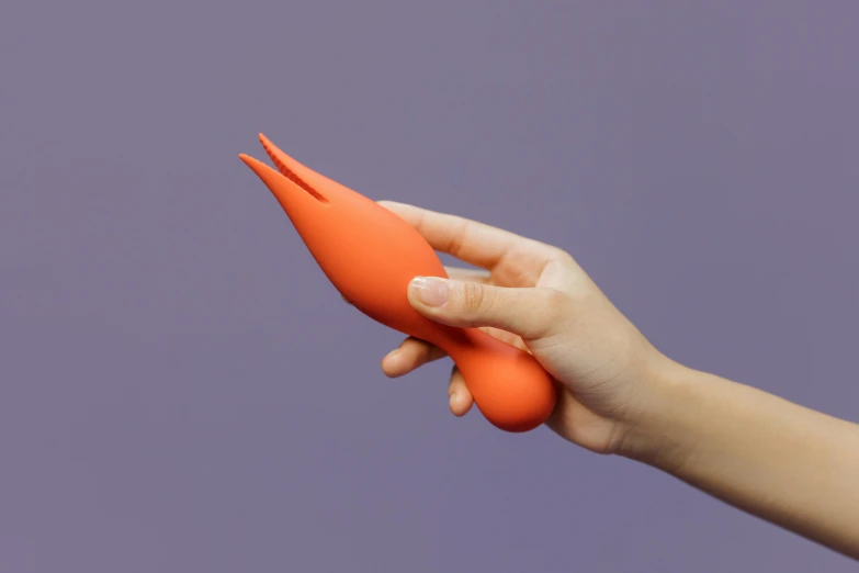a person holding a toy carrot in their hand, inspired by Man Ray, silicone skin, red, multi - coloured, large tail