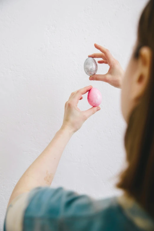 a woman using a blow dryer to dry her hair, unsplash, happening, a woman holding an orb, translucent eggs, hero shot, pink