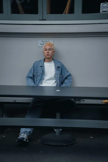a man sitting on a bench in front of a window, by Jang Seung-eop, unsplash, hyperrealism, albino hair, in court, hito steyerl, casual pose