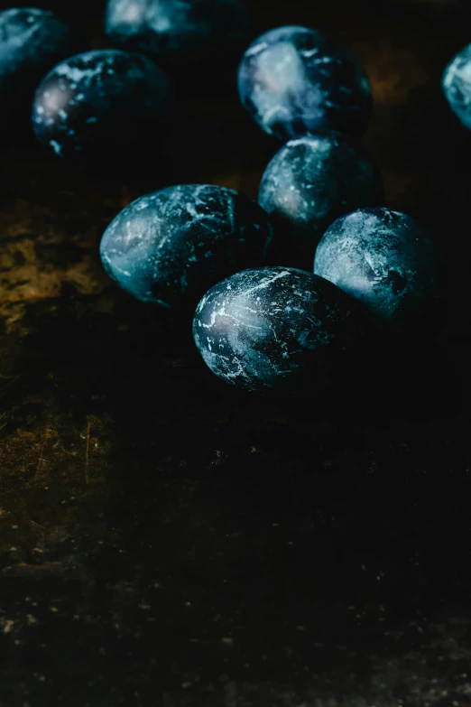 a pile of blueberries sitting on top of a table, inspired by Elsa Bleda, process art, translucent eggs, dark stone, dramatic product shot, covered in white flour