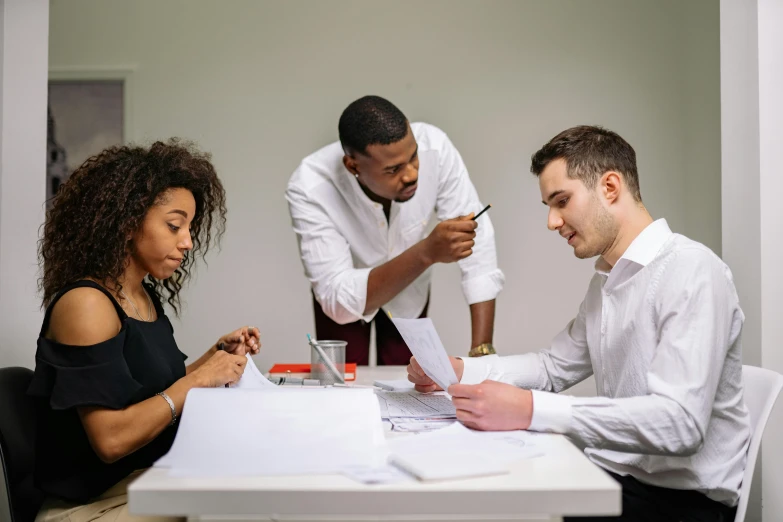 a group of people sitting around a table, on a desk