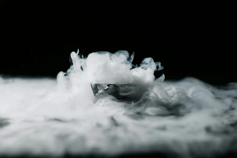 a glass filled with liquid sitting on top of a table, unsplash, surrealism, thick white detailed smoke, made of liquid metal and marble, an film still, cryo engine