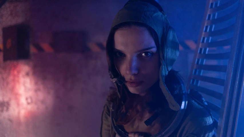 a woman in a space suit standing next to a wall, antipodeans, anya taylor - joy vampire queen, film still from 'tomb raider', angela sarafyan, halo over her head