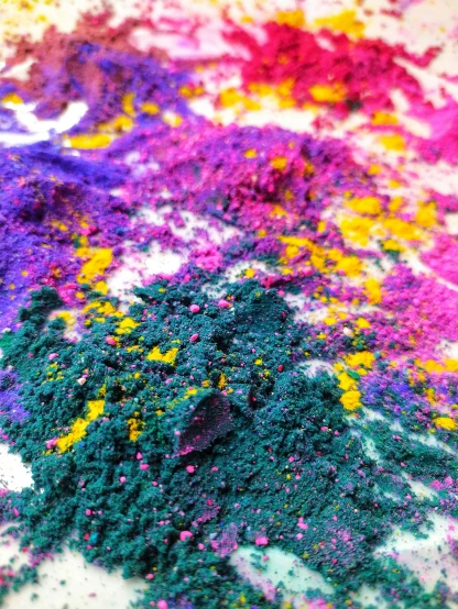 a pile of colored powder sitting on top of a table, inspired by Sam Francis, process art, psychedelic and glittering, yellow purple green, medium closeup, colorful aesthetic