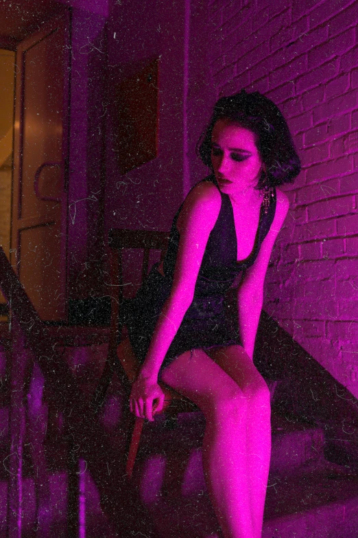 a woman sitting on the steps of a building, an album cover, inspired by Elsa Bleda, trending on pexels, serial art, purple lights, krysten ritter, film noir style, cyberpunk strip clubs