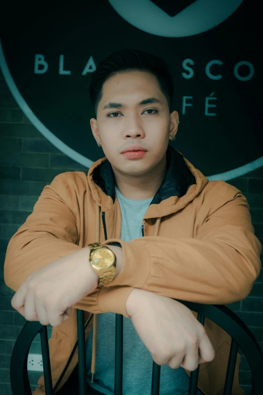 a man sitting in a chair with a watch on his wrist, a picture, inspired by Eddie Mendoza, pexels contest winner, he is wearing a brown sweater, discord profile picture, wearing a black jacket, ayan nag