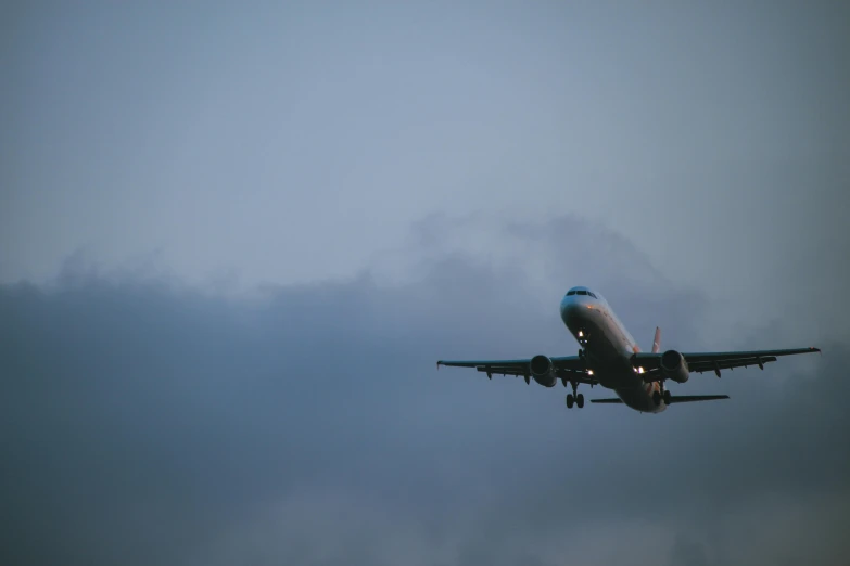 a large jetliner flying through a cloudy sky, by Carey Morris, pexels contest winner, landing gear, sky blue, late evening, front facing