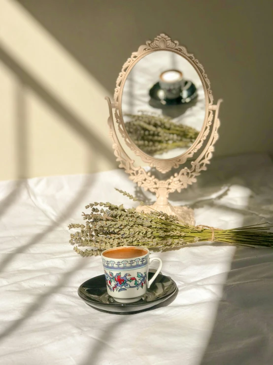 a tea cup sitting on top of a table next to a mirror, by Lucia Peka, trending on unsplash, arts and crafts movement, lavender plants, ottoman miniature style, 1990s photograph, taken on iphone 14 pro